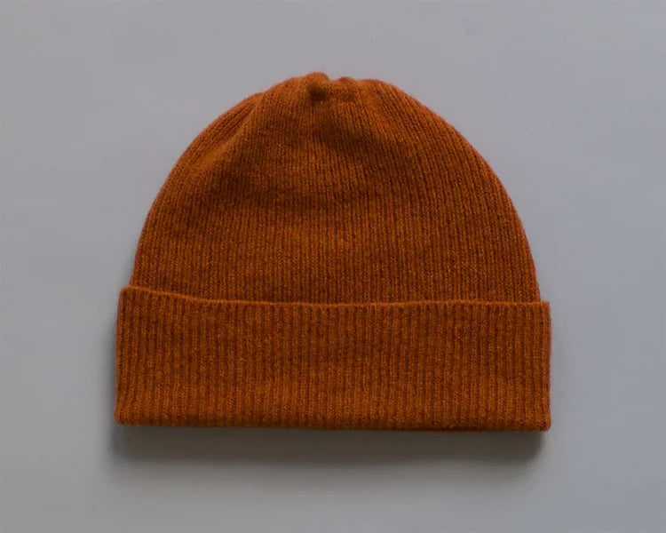 Orange knit beanie on a grey background