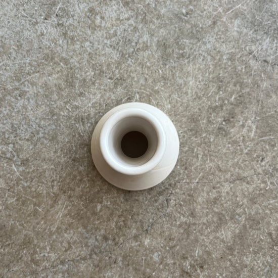 White cylindrical object on a gray textured surface