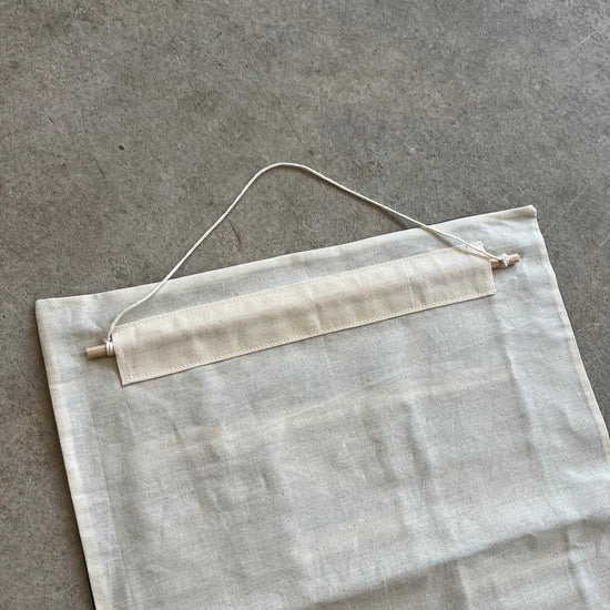 Gray fabric panel with a wooden dowel hanging on a gray surface