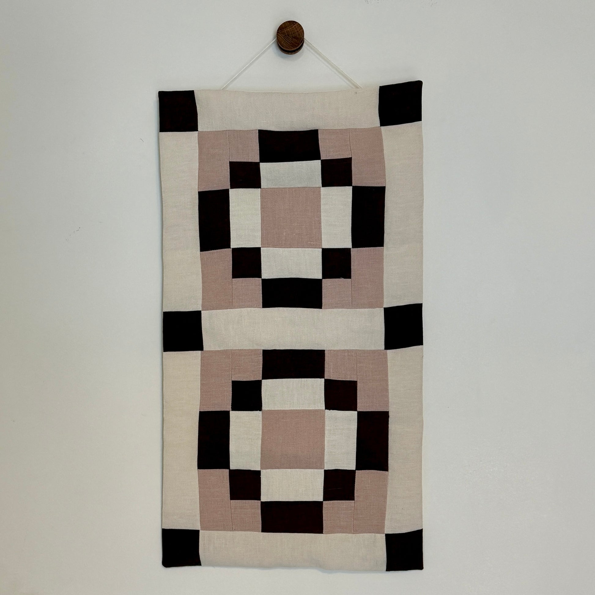 Decorative wall hanging with geometric pattern on a plain background