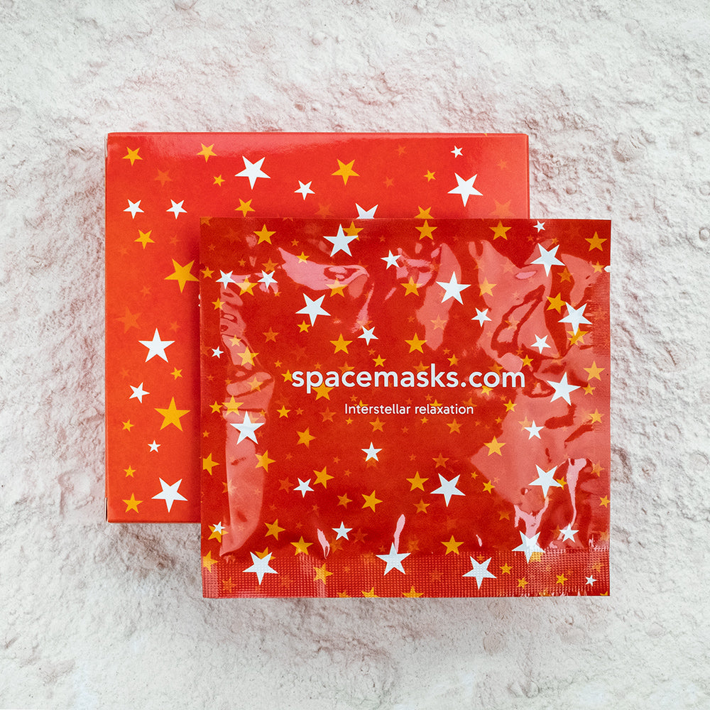 Red packaging with star patterns and 'spacemasks.com' branding on a textured white background