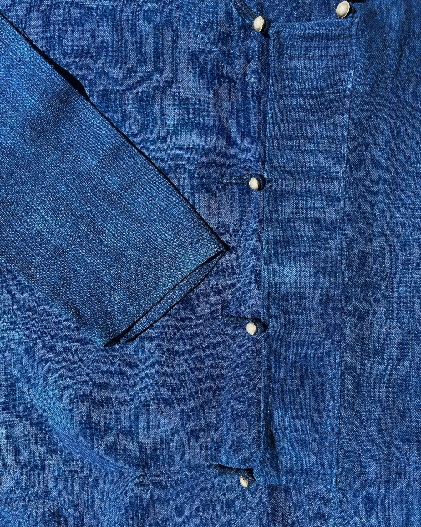Close up of a blue shirt with metal buttons