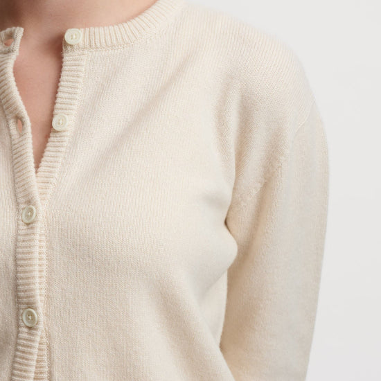 Close-up of a beige cardigan on a plain background