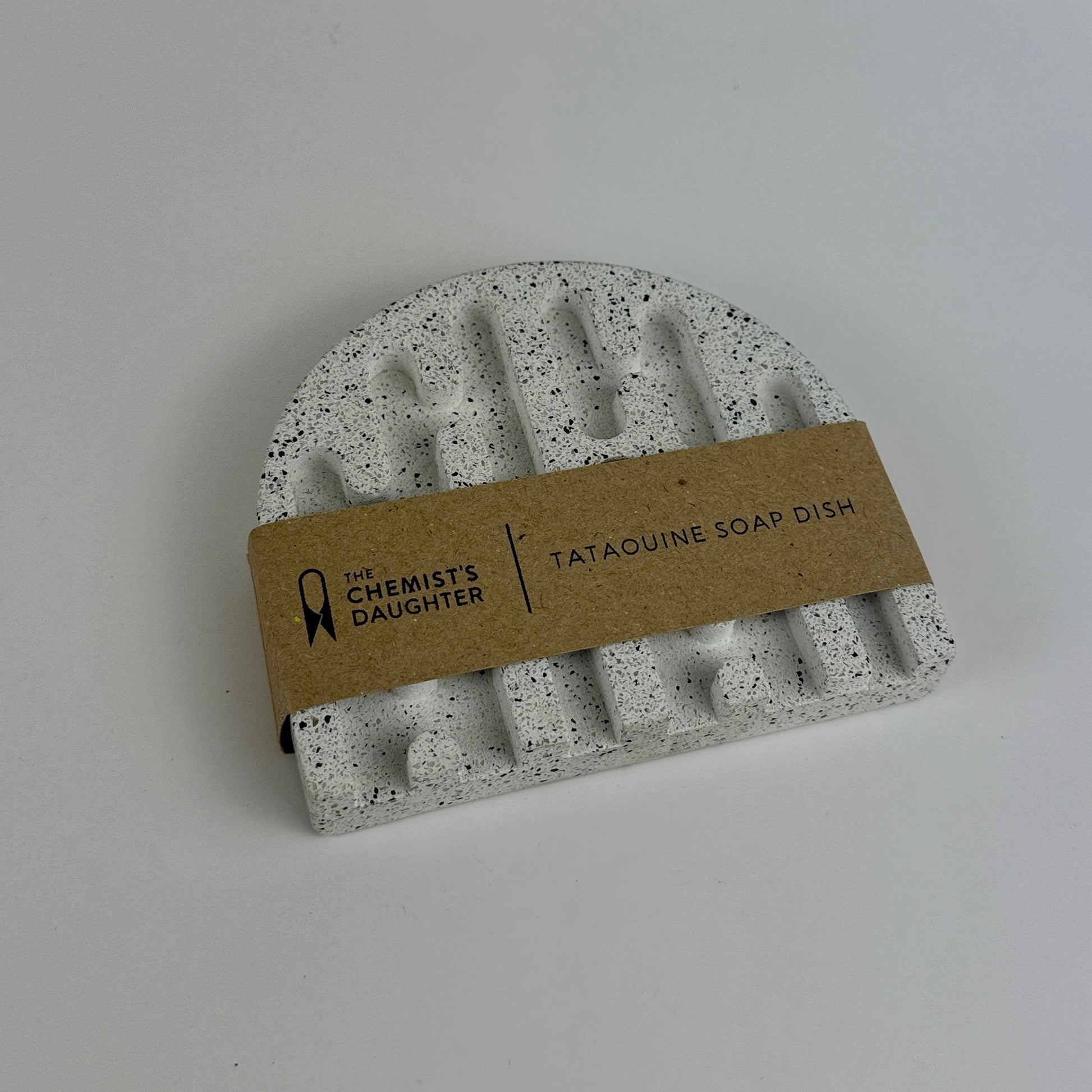 Speckled gray soap dish with a brown label on a light gray background