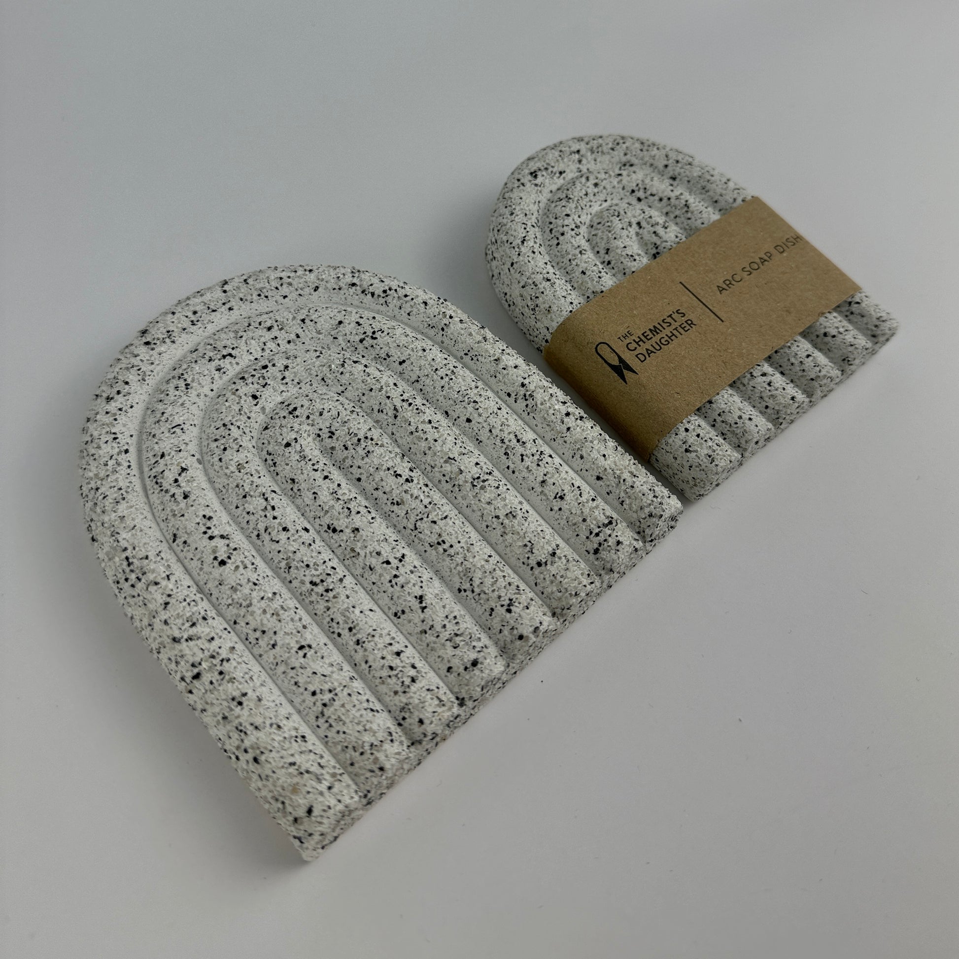 Speckled gray and white beanie with a brown label on a light gray background
