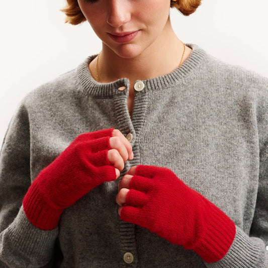Person wearing red gloves and a gray sweater on a white background
