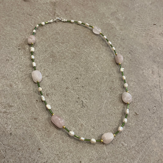 Necklace with pink and pearl beads on a concrete surface