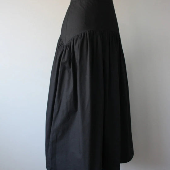 Black high waisted skirt on a mannequin against a plain background