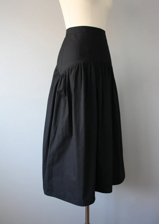 Black high waisted skirt on a mannequin against a plain background