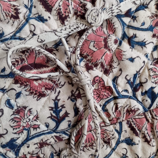 Close-up of floral patterned fabric with pink and blue colors on a white background