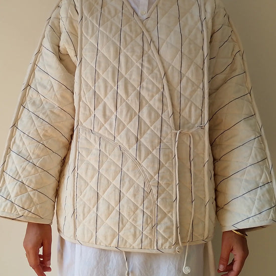 Quilted beige jacket worn by a person on a plain background