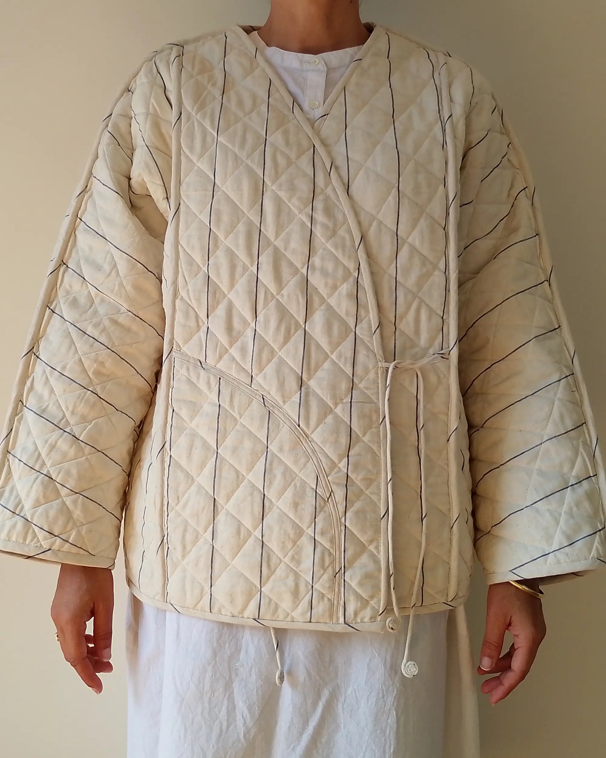 Quilted beige jacket worn by a person on a plain background