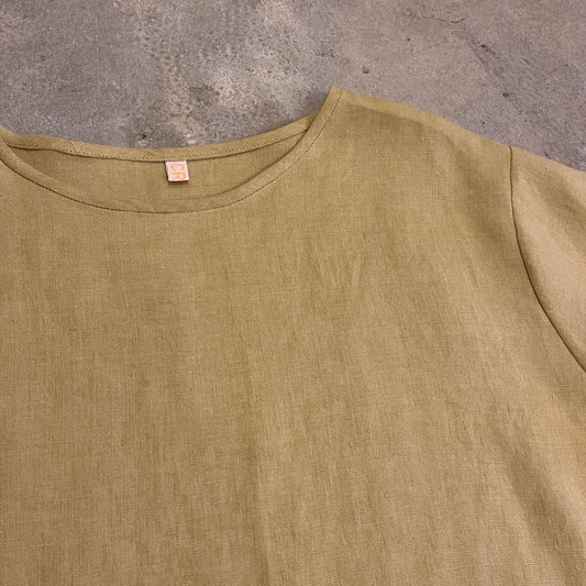 A yellow top on a dark beige backgrond
