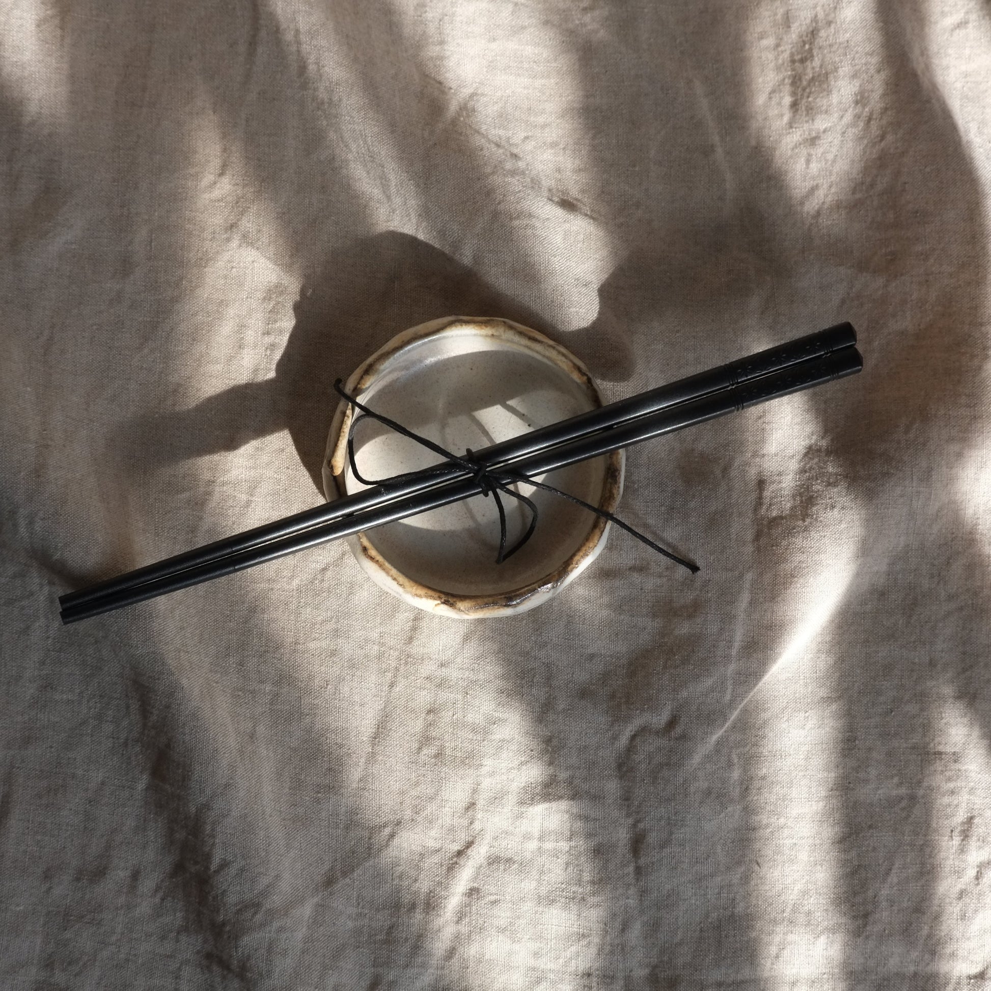 Black chopsticks on a white fabric background