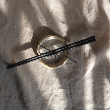 Black chopsticks on a white fabric background