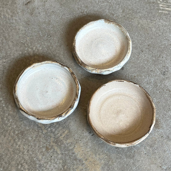 Three small ceramic bowls on a textured gray surface