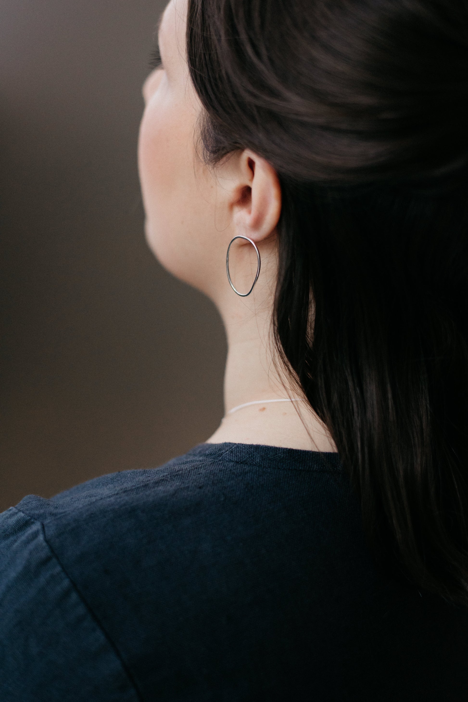 A pair of sterling silver oval earrings worn by a model