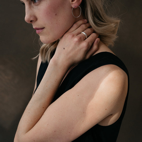 A pair of sterling silver oval earrings worn by a model
