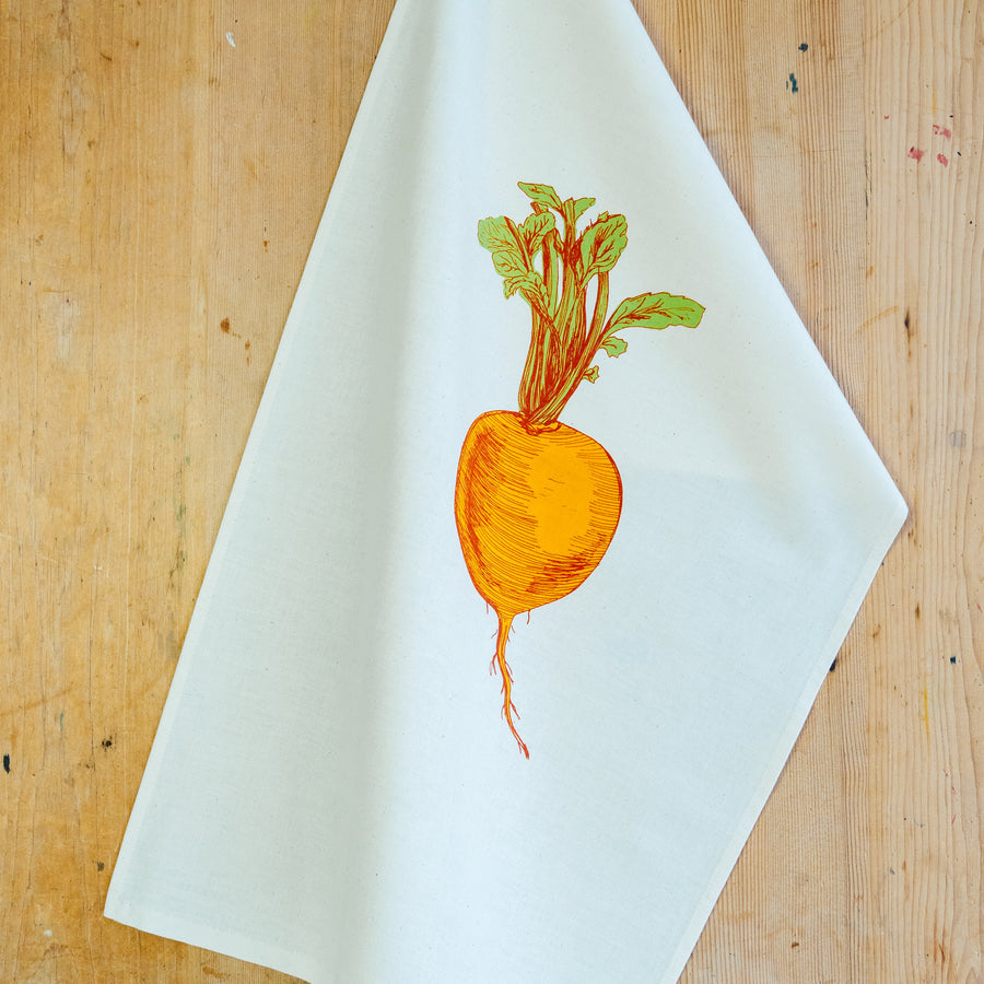 orange suede illustrated tea towel on a wooden surface