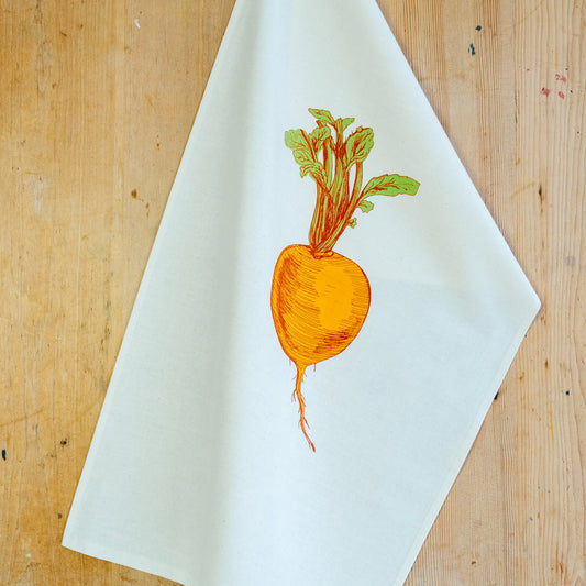 orange suede illustrated tea towel on a wooden surface