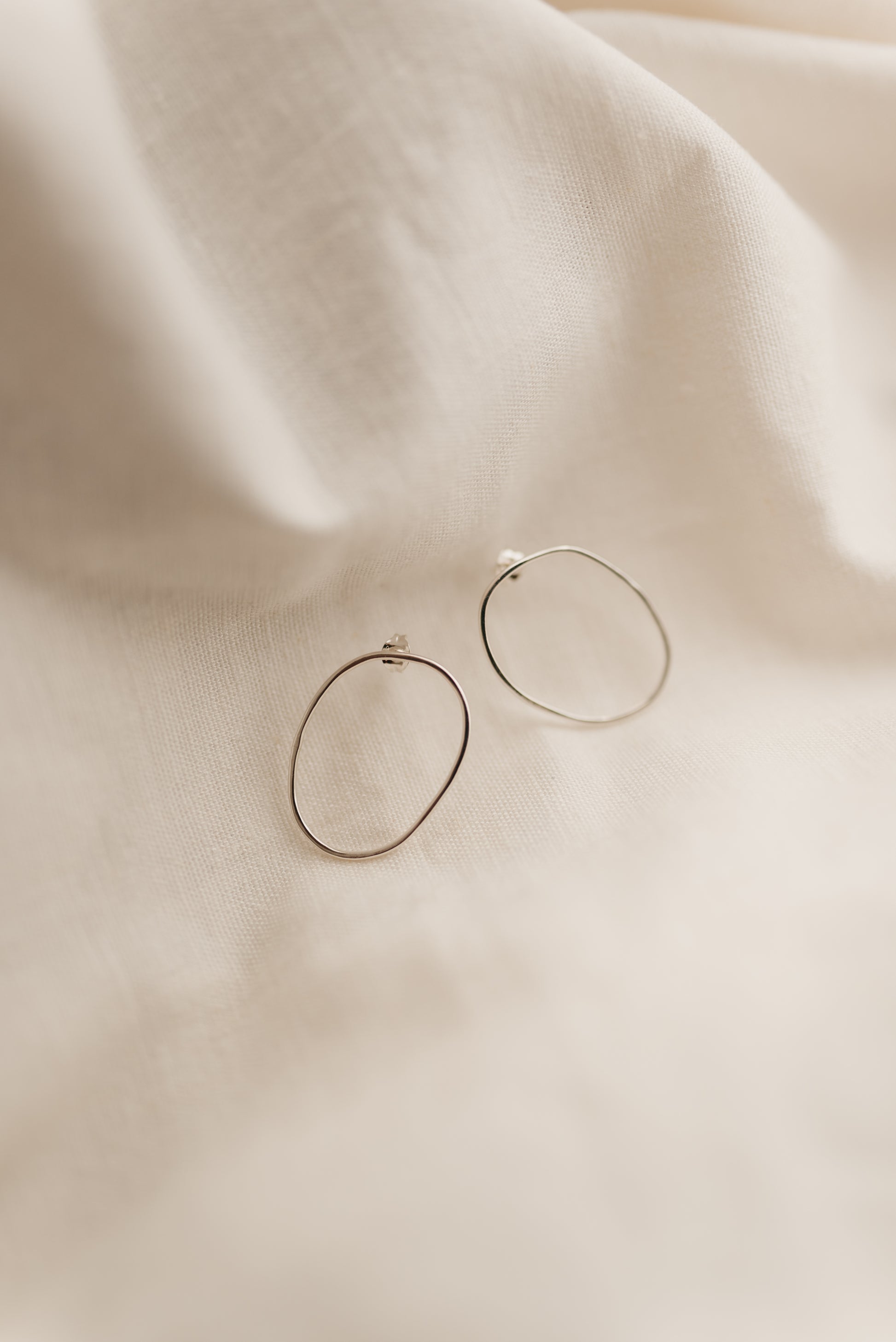 a pair of sterling silver free form oval hoop studs