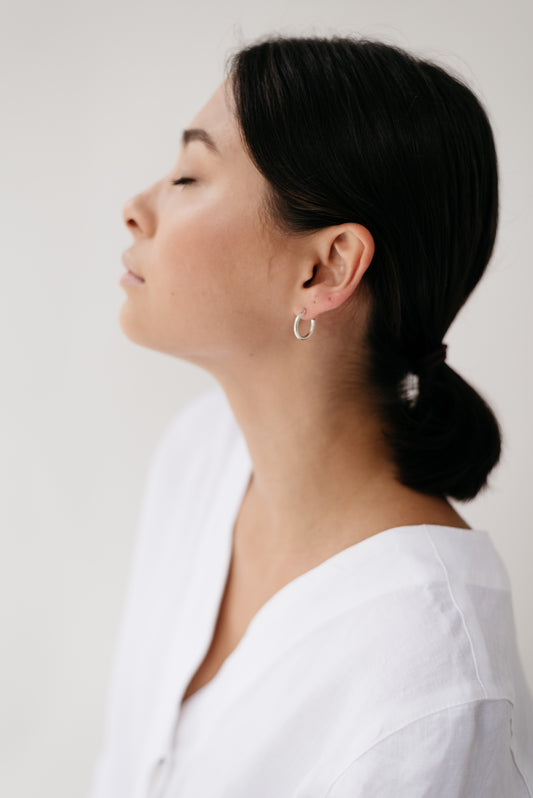 A model wearing a pair of Sterling Silver hoops