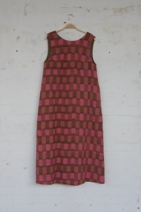 Red and brown checkered dress on a white surface