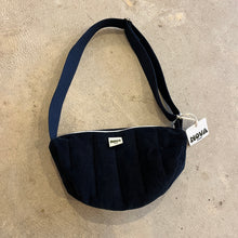 Load image into Gallery viewer, Navy blue padded corduroy cross body bag with adjustable strap and zip on grey concrete background
