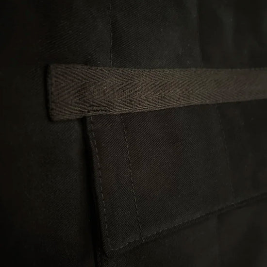 Close-up of a black fabric with a strap on a dark background