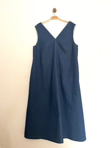 Indigo denim aline sleeveless long dress with a v-neck and centre seam on a cream background