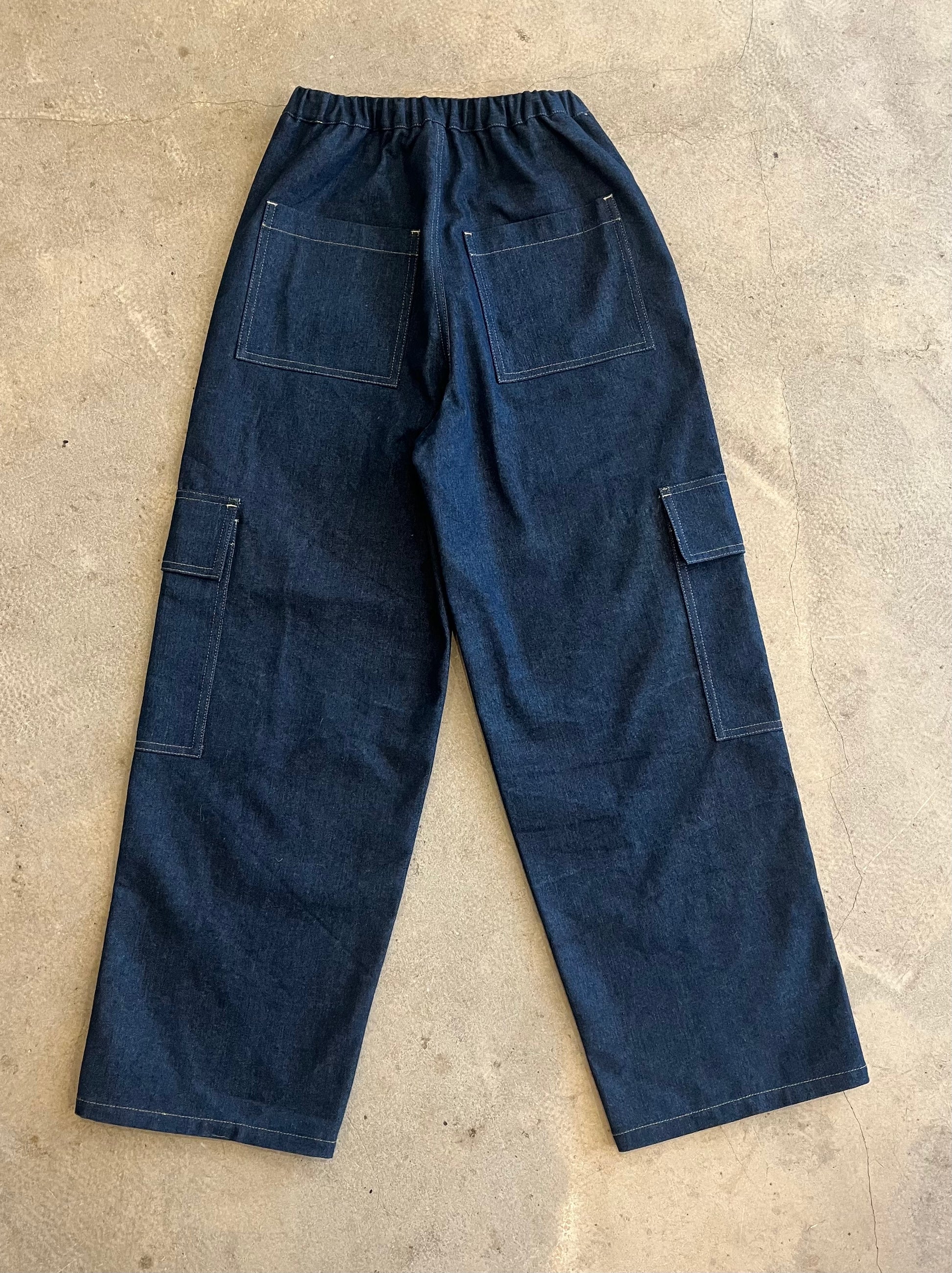 Blue work pants on a beige concrete floor