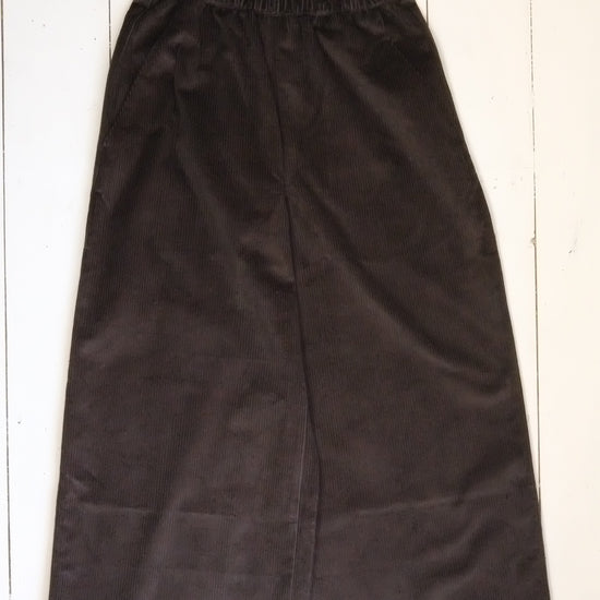 Pair of black pants on a white wooden floor