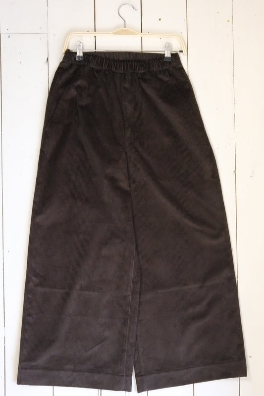 Pair of black pants on a white wooden floor