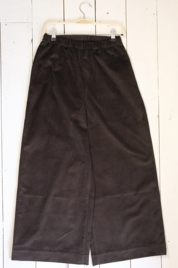 Pair of black pants on a white wooden floor
