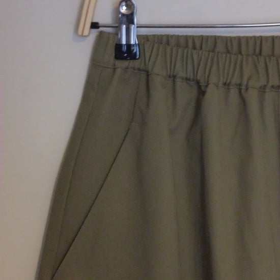 Close-up of a green skirt with a zipper on a beige background