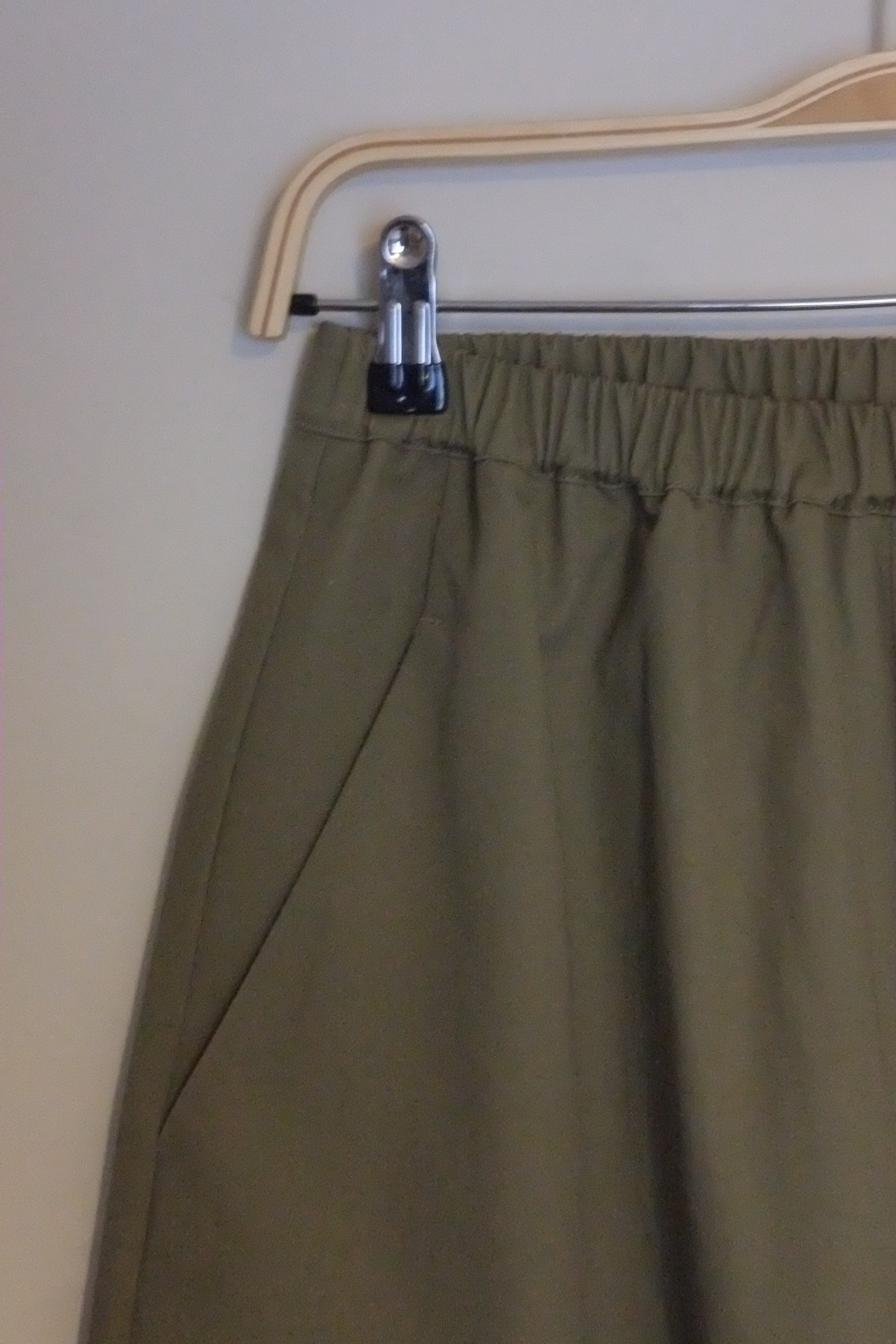 Close-up of a green skirt with a zipper on a beige background