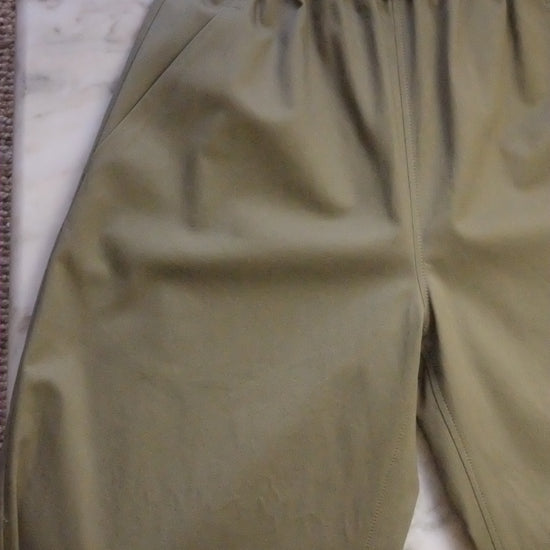 Green pants on a white surface with a brown textured background