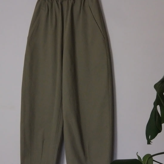 Green pants on a hanger against a white background