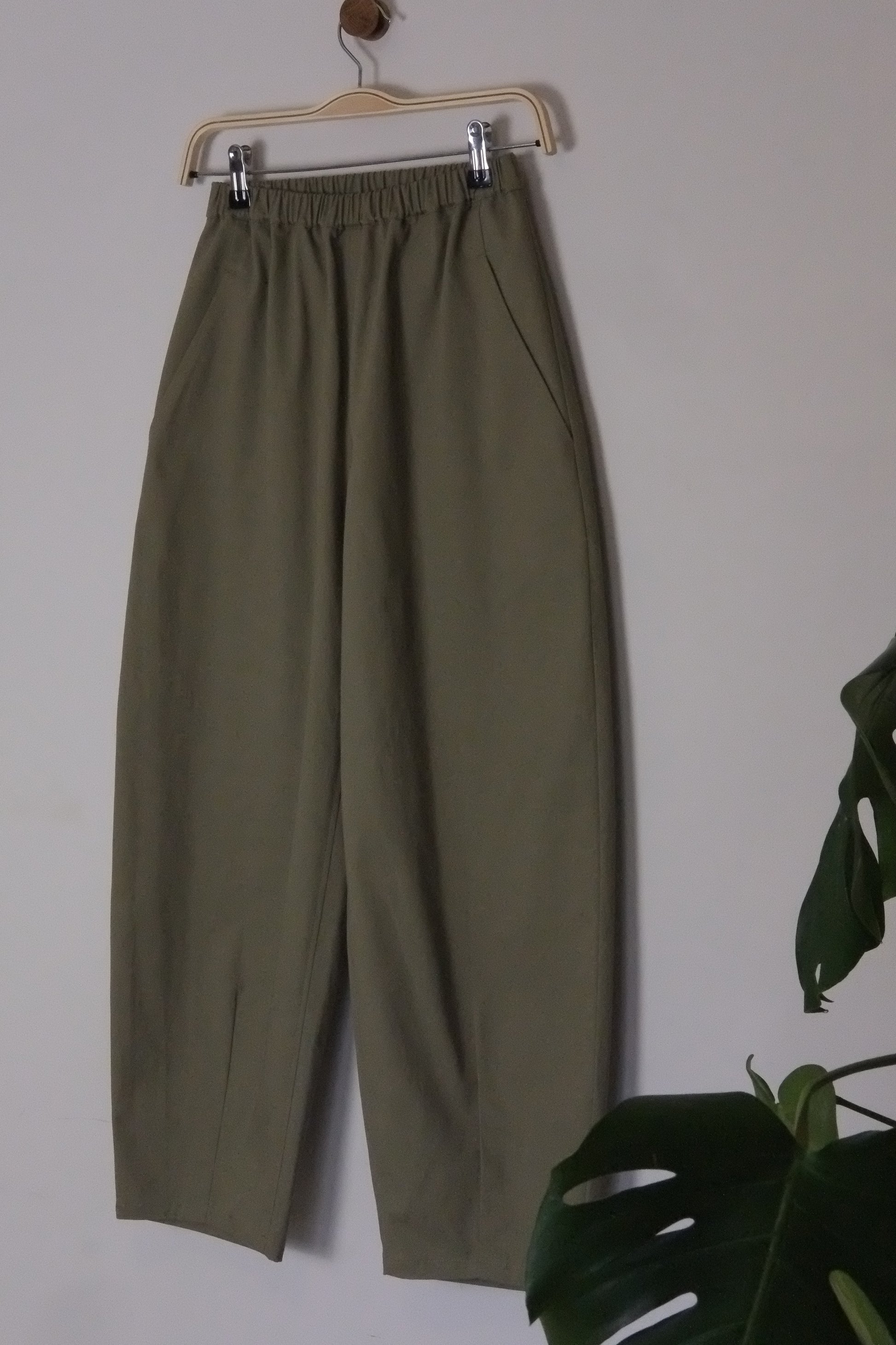 Green pants on a hanger against a white background
