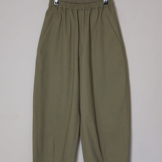 Green pants on a hanger against a white background