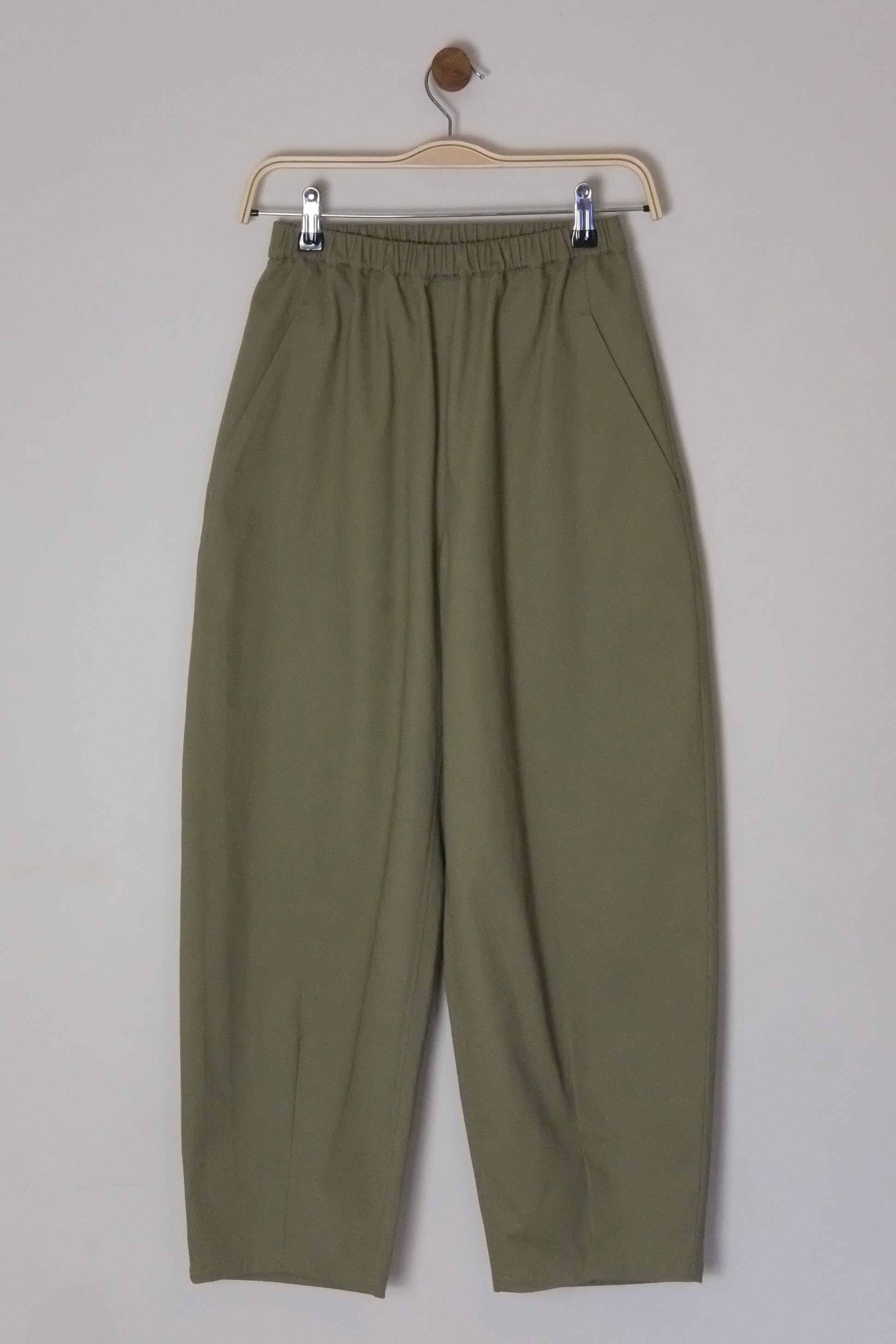 Green pants on a hanger against a white background