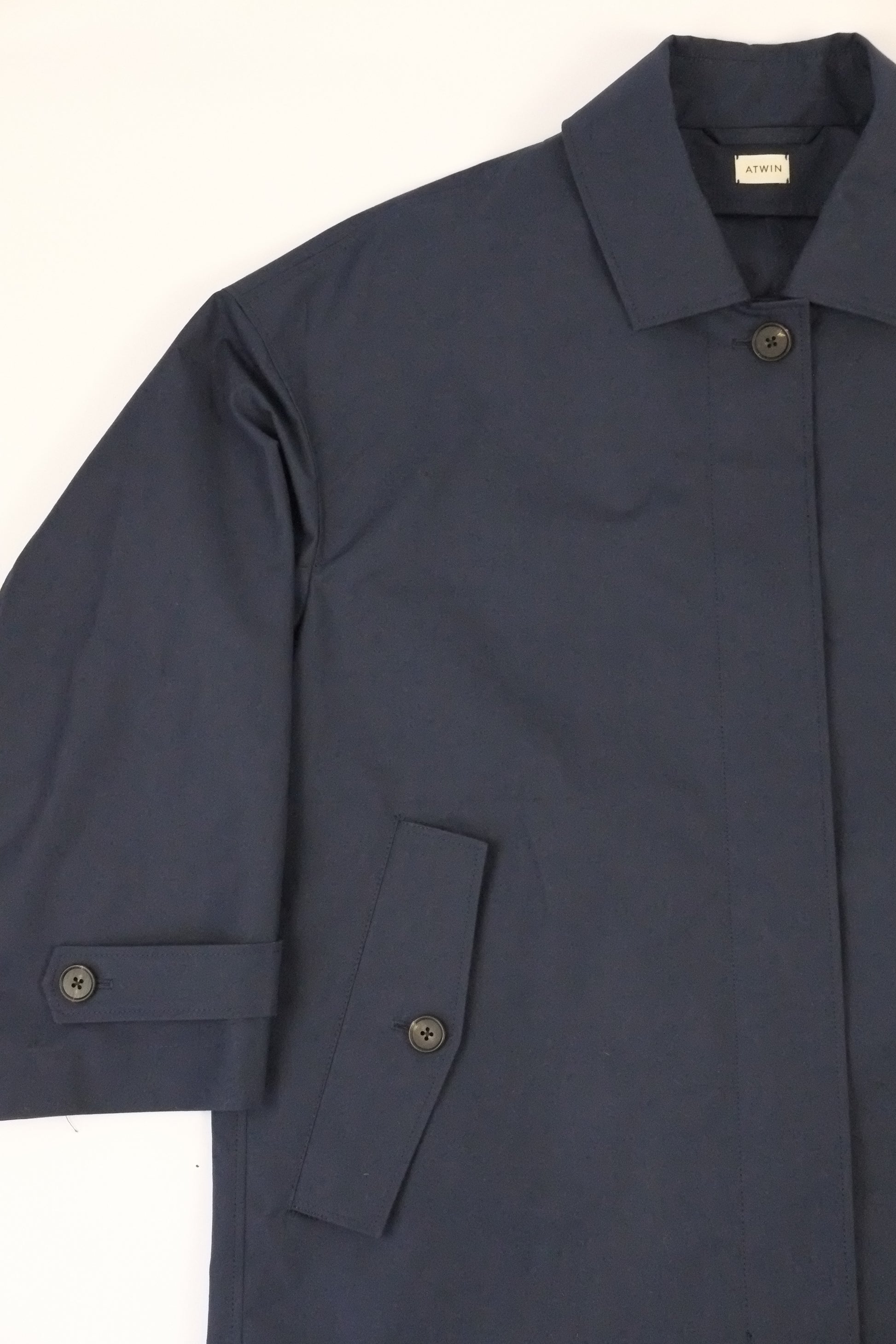 Navy blue jacket with rolled-up sleeves on a white background