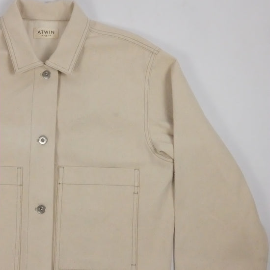 Beige jacket with a brand label on a light gray background