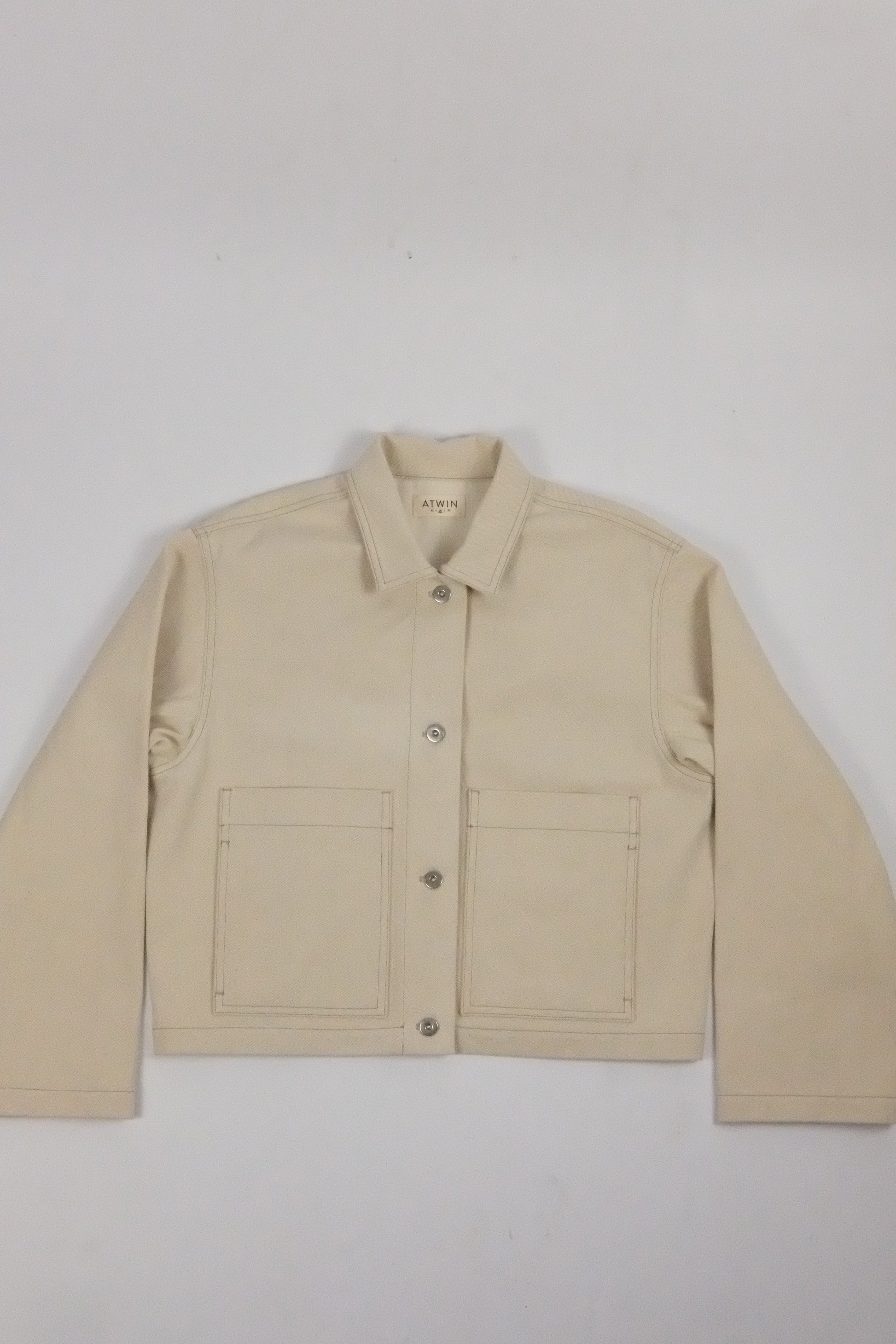 beige denim jacket on a white background 