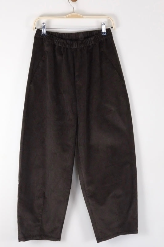 brown cord barrel leg trousers hanging on a white background