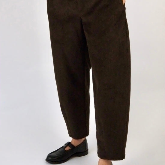model wearing brown corduroy trousers against a white backdrop