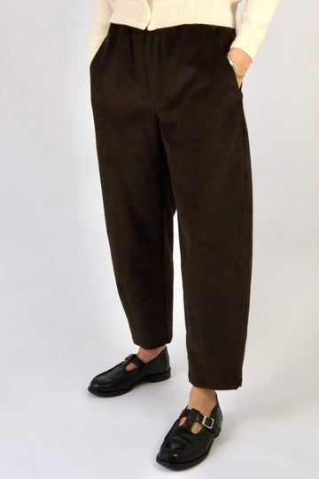 model wearing brown corduroy trousers against a white backdrop