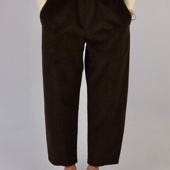 model wearing atwin the label brown corduroy trousers against a white backdrop