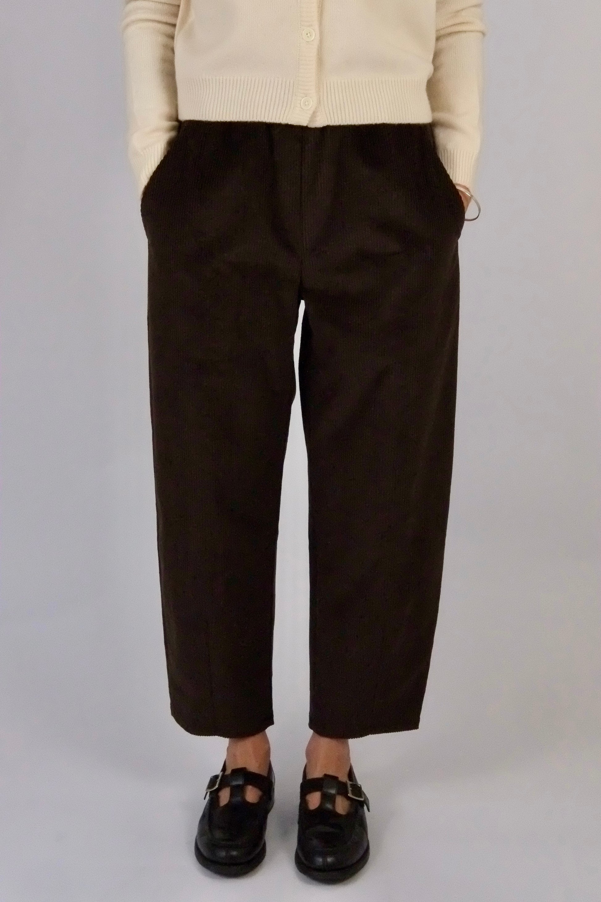 model wearing atwin the label brown corduroy trousers against a white backdrop