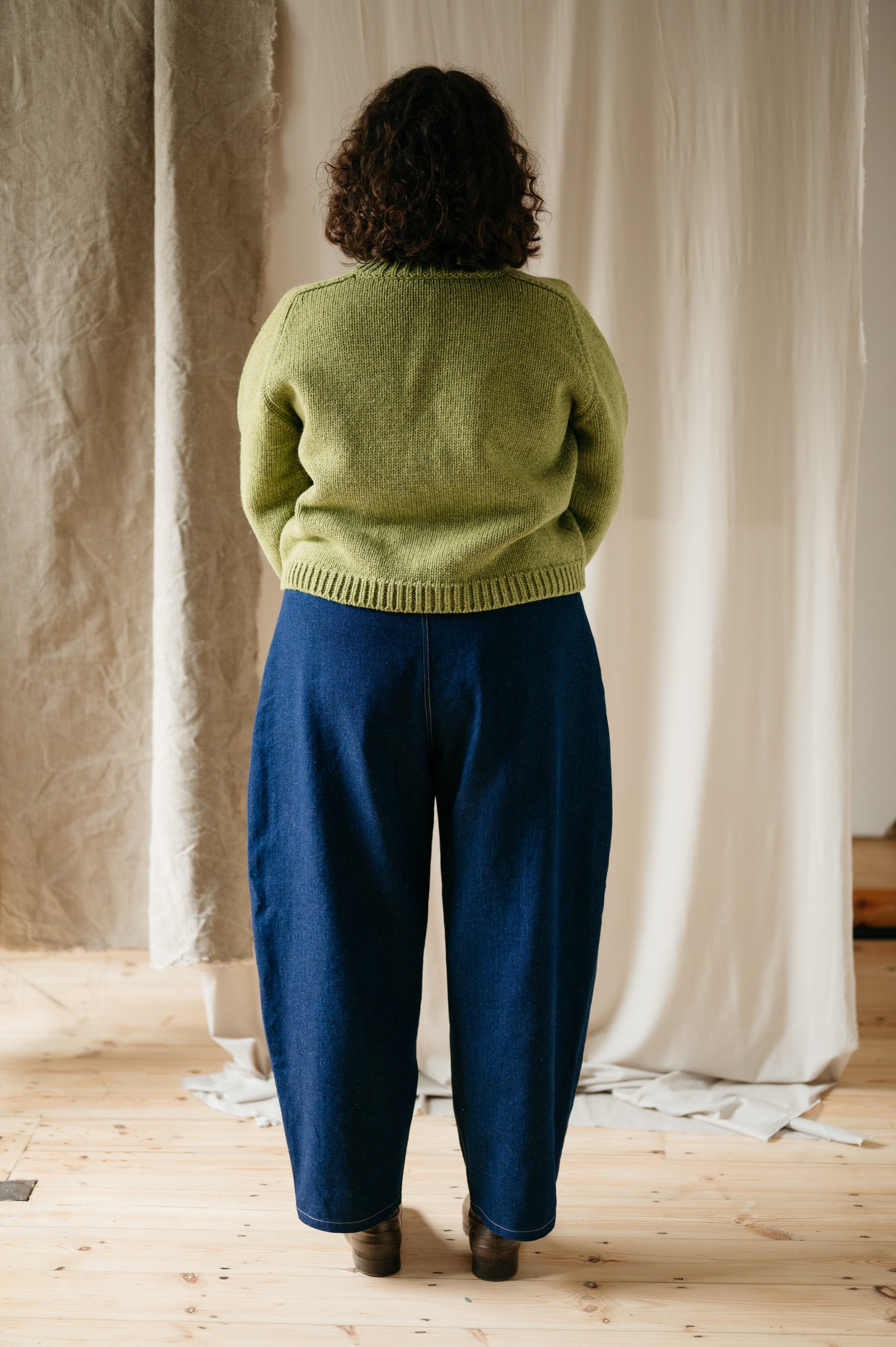Model wearing barrel leg denim trousers – full back view
